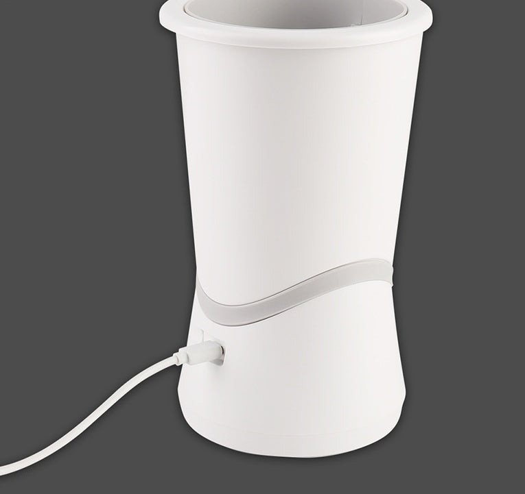 Vista trasera del limpiador automático de patas Animexus CleanPaws Pro™ conectado mediante cable USB-C para recargar su batería, con diseño ergonómico y portátil ideal para limpiar la suciedad de perros y gatos en casa o durante viajes.