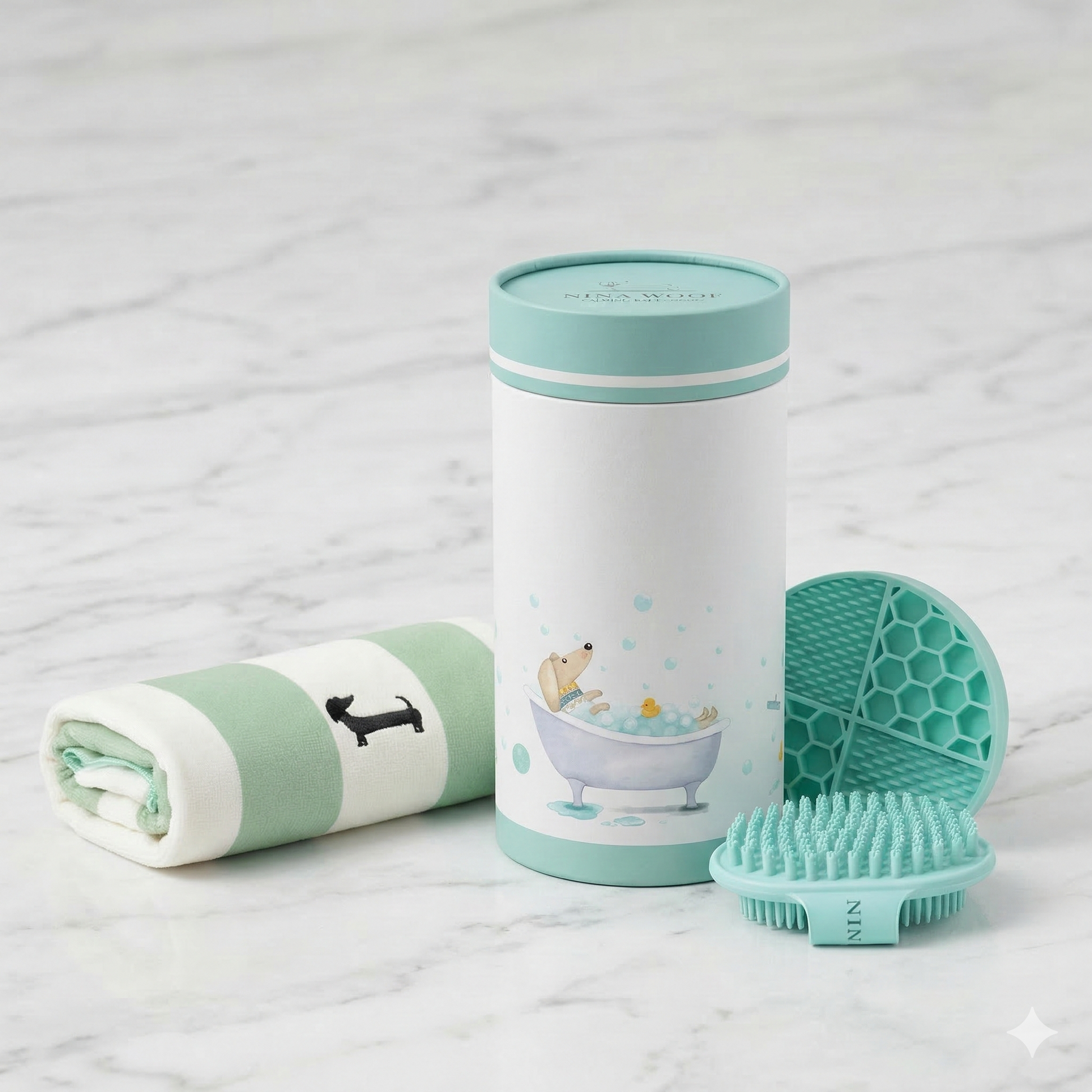 Kit de baño esencial premium para perros sobre superficie de mármol elegante. Incluye toalla absorbente a rayas, cepillo de masaje de silicona, alfombrilla lick mat y envase cilíndrico ilustrado.