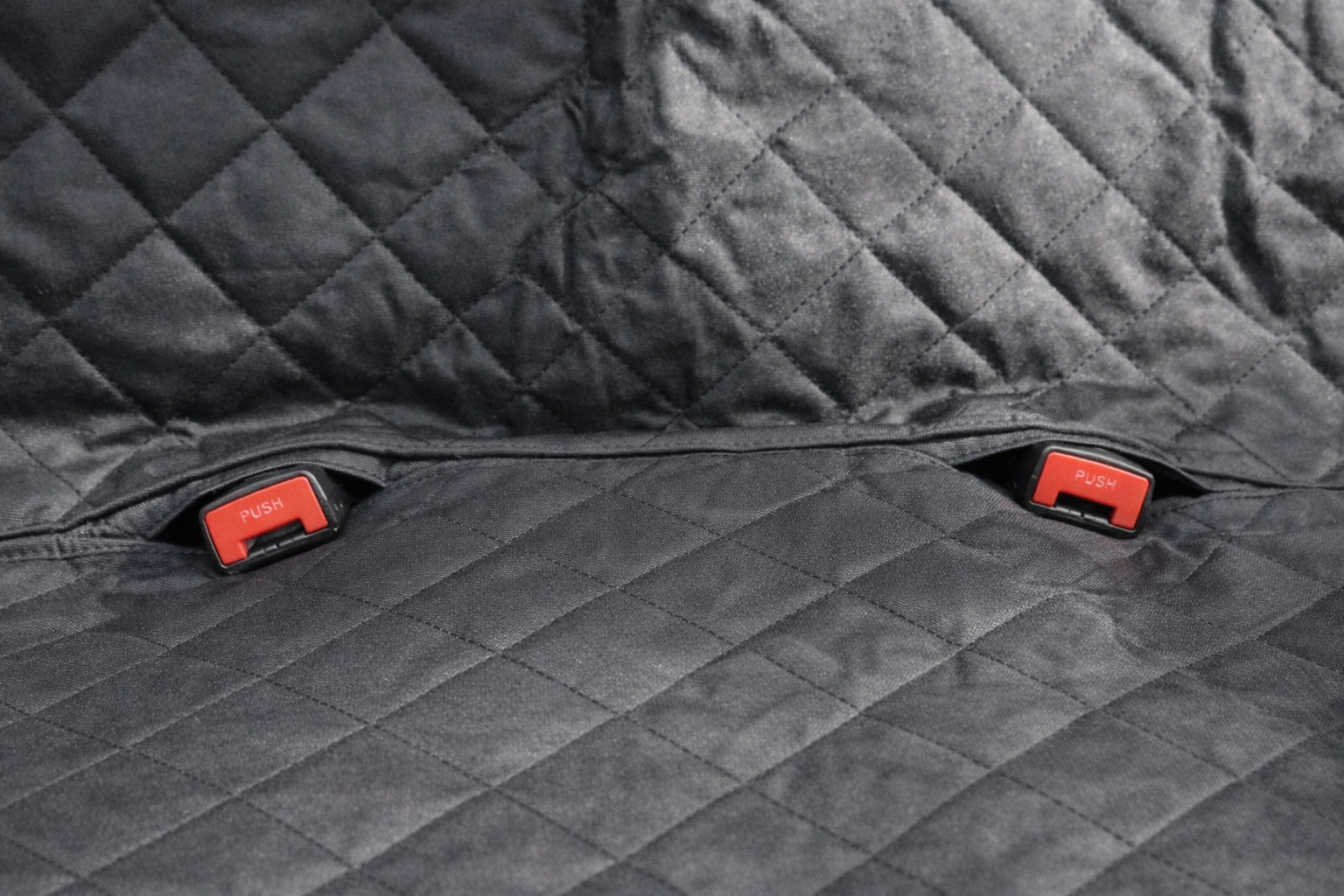 Detalle de las aperturas para las hebillas del cinturón de seguridad en el protector de asiento para coche