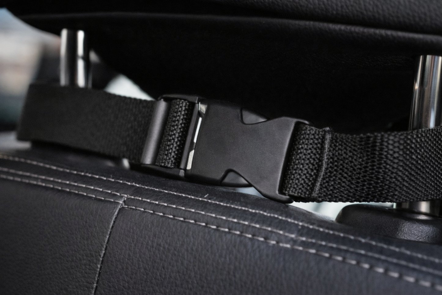 Detalle de la correa y hebilla de fijación al reposacabezas del protector de asiento para coche